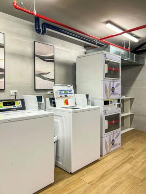A laundry facility with washing machines and dryers, a control panel, and a ventilation system. - Geko l Contemporary 1BR in Barranco w/ balcony (Lima)