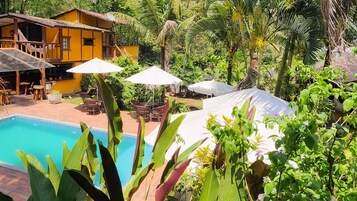 Een buitenzwembad, parasols voor strand/zwembad