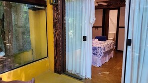 Een kamer met een bed, een raam en een deur.