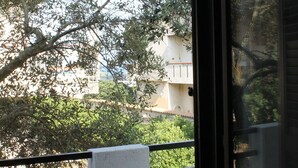 Un balcon donnant sur des arbres et des immeubles.