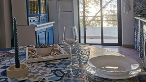 Un coin repas avec une nappe à motifs, un verre d’eau, un bol et une assiette.