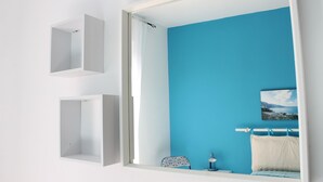 Une salle de bain avec un mur bleu, un lavabo blanc et un miroir.