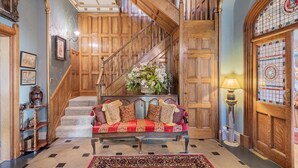 Un magnifique escalier avec des rampes en bois et une composition florale au sommet.