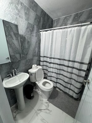 Ein Badezimmer mit Waschbecken, Toilette und einer gestreiften Duschvorhang.