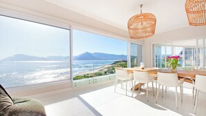 Une chambre moderne dotée d’une grande porte vitrée donnant sur un balcon avec vue sur la mer.