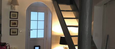 A staircase leading to a loft area with a lamp on the landing.