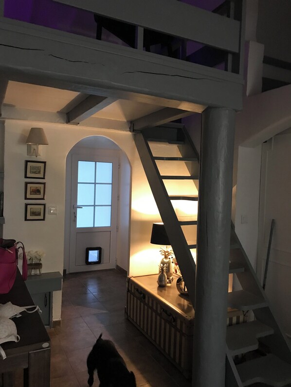 A staircase leading to a loft area with a lamp on the landing.