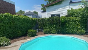 A rectangular swimming pool with clear blue water, surrounded by a concrete deck. - Spacious Century 3-bed in Downtown Wellington with in Ground Pool and parking! (Prince Edward)