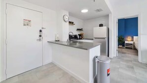 Een moderne keuken met witte kasten, een roestvrijstalen kookeiland en een inbouwoven.