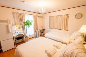 A hotel room with a bed, a vanity with a mirror, a plant, a radiator, and a clock on the wall. - Japanese-style family house in the western of Tokyo, DP Oyamamachi (町田市小山町)
