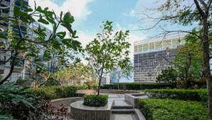 A landscaped courtyard with a central pathway, surrounded by greenery and modern buildings in the background. - Luxury 1BR at BGC Uptown with Free Parking (Taguig City)