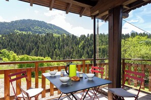 A balcony with a table set for breakfast, overlooking a forested mountain. - Au coeur des Soms en Chartreuse (Saint-Pierre-de-Chartreuse)