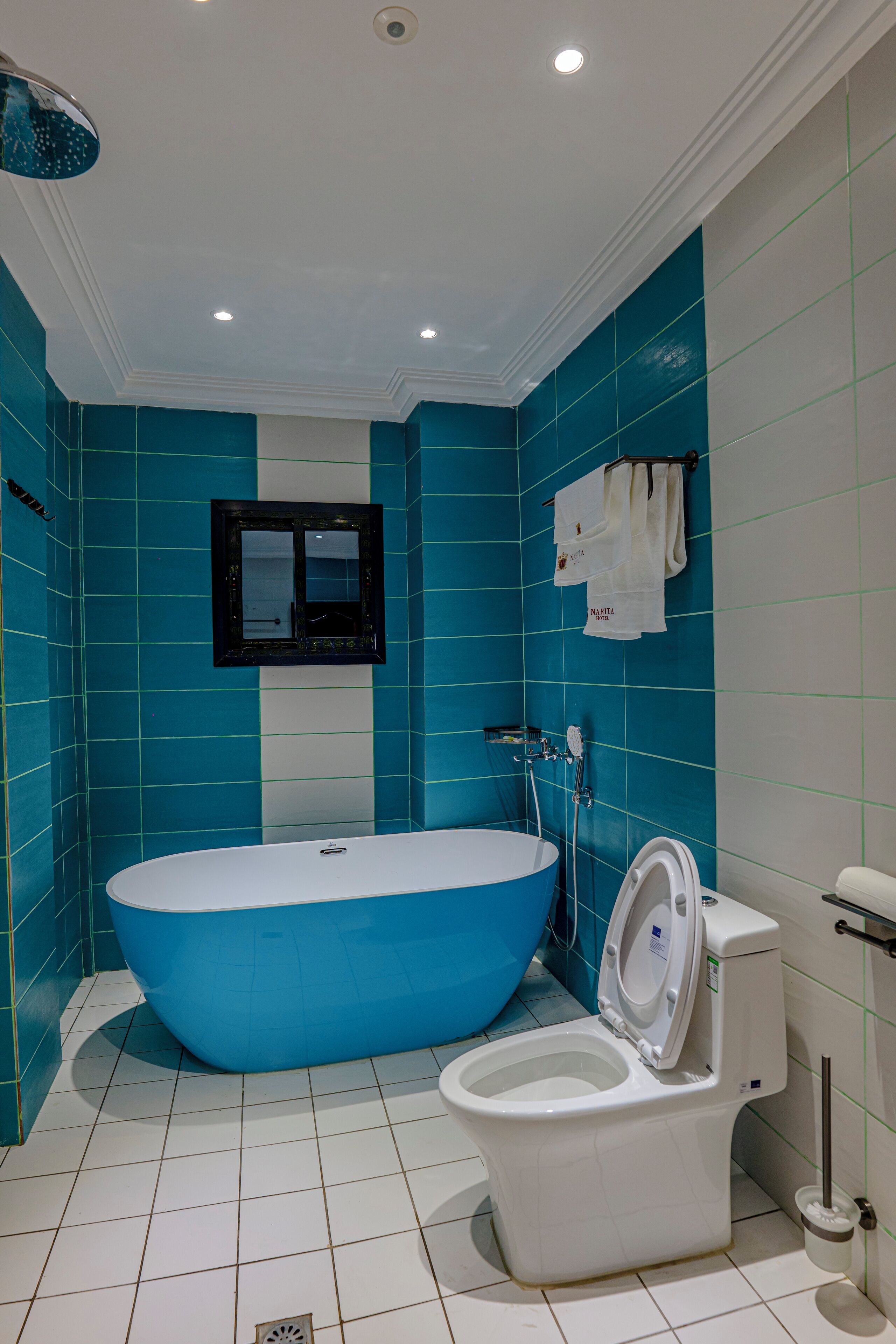 A bathroom with a large bathtub, a toilet, and a mirror.