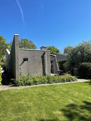 A modern stone building with a chimney, a window, and a door. - Detached villa for 5/6 persons, 3 bedrooms, 2 bathrooms, dog welcome, Brouwershaven (Brouwershaven)