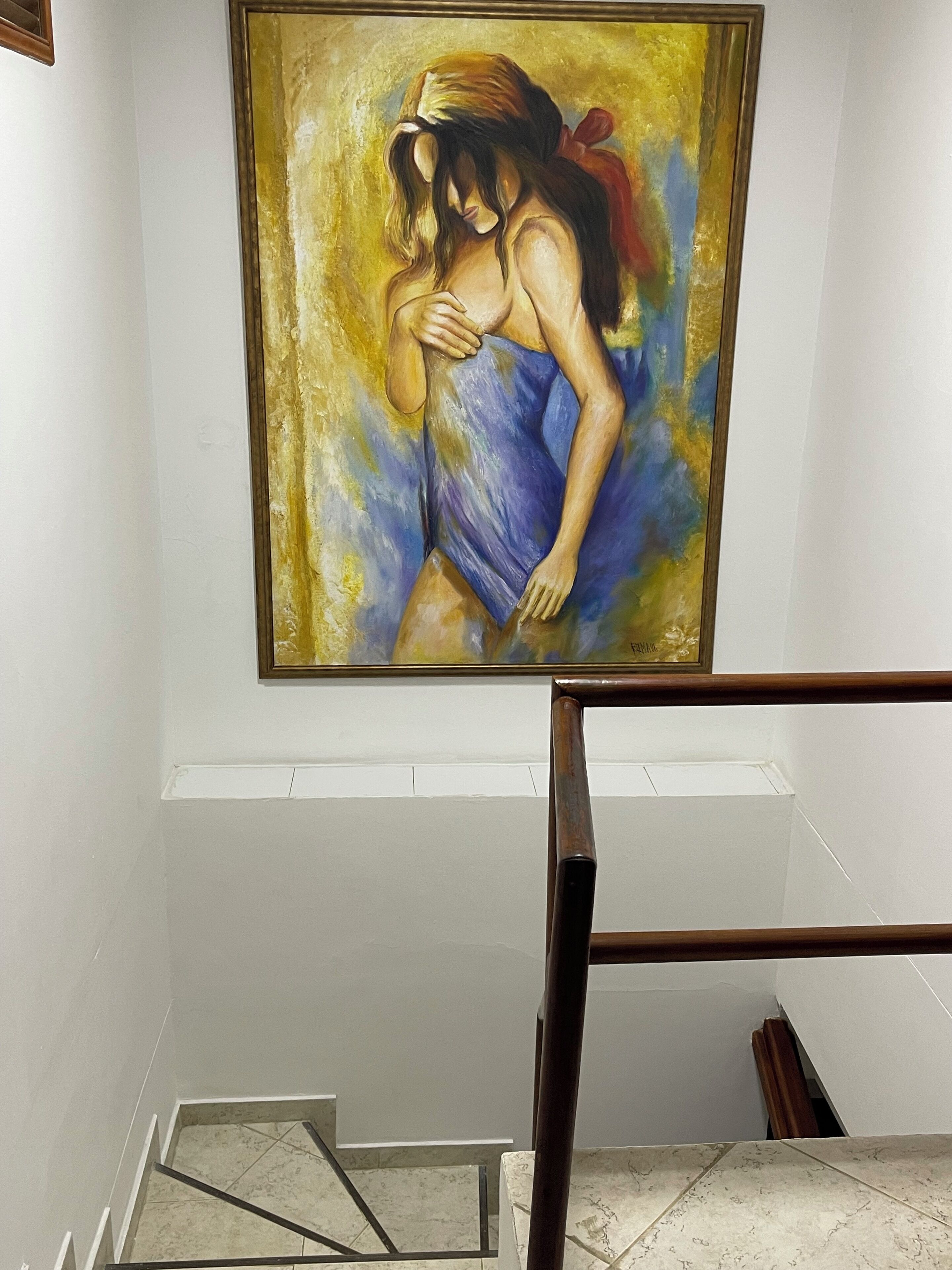 A staircase with a painting of a woman in a blue dress.