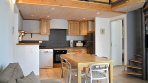 Une cuisine moderne avec des meubles de rangement en bois, une table à manger et des chaises.
