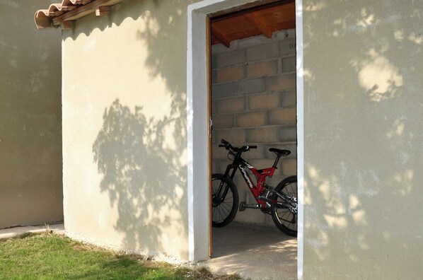 A doorway leading to a brick building with a bicycle parked inside.
