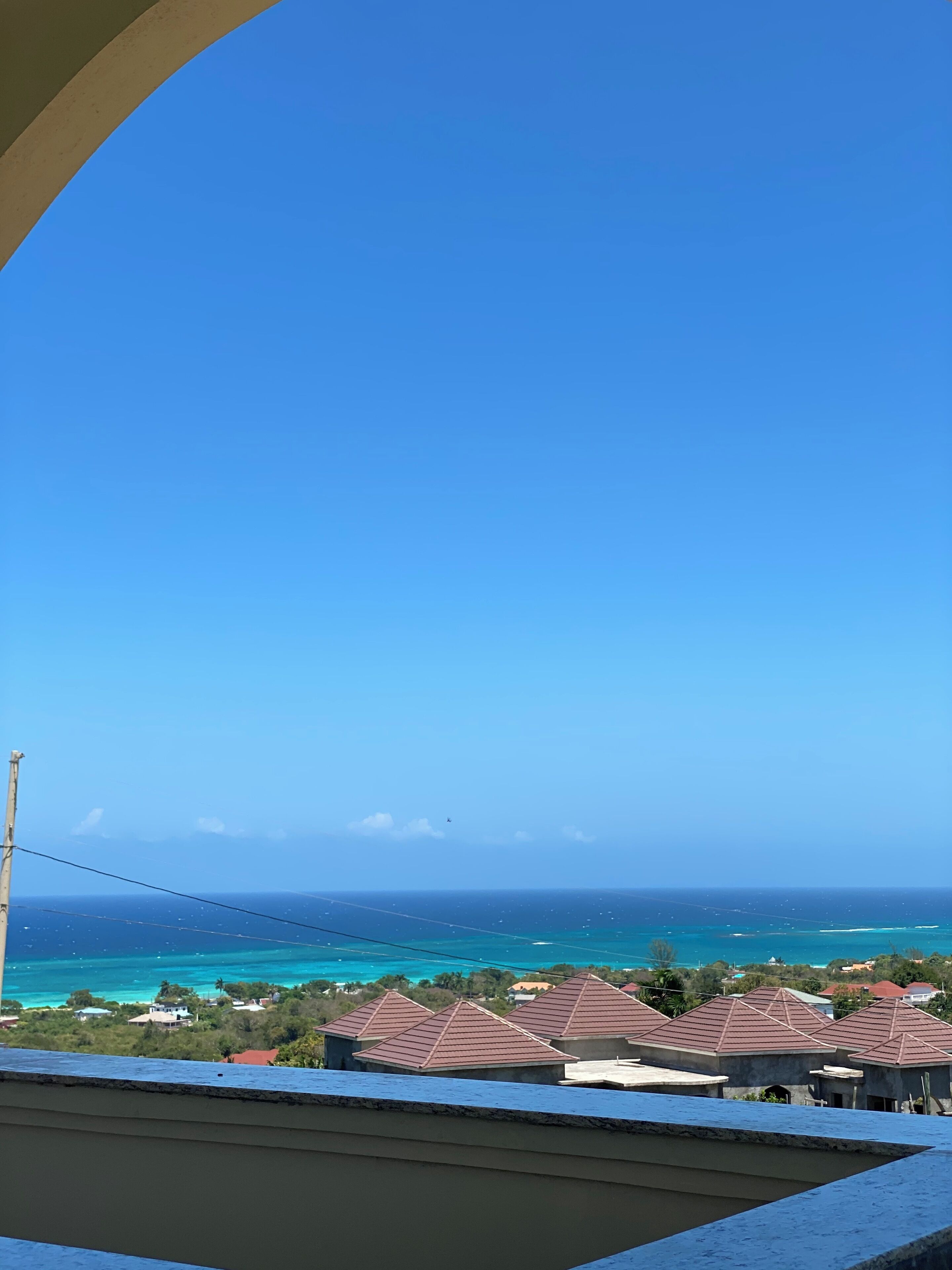 Une vue d’une zone côtière avec des maisons et un ciel bleu dégagé.