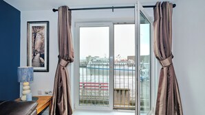Une pièce avec vue sur une rivière, un banc, une lampe et un tableau encadré au mur.