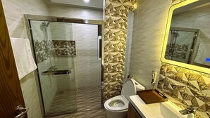 Ein Badezimmer mit Duschkabine, Toilette und Waschbecken mit Spiegel.