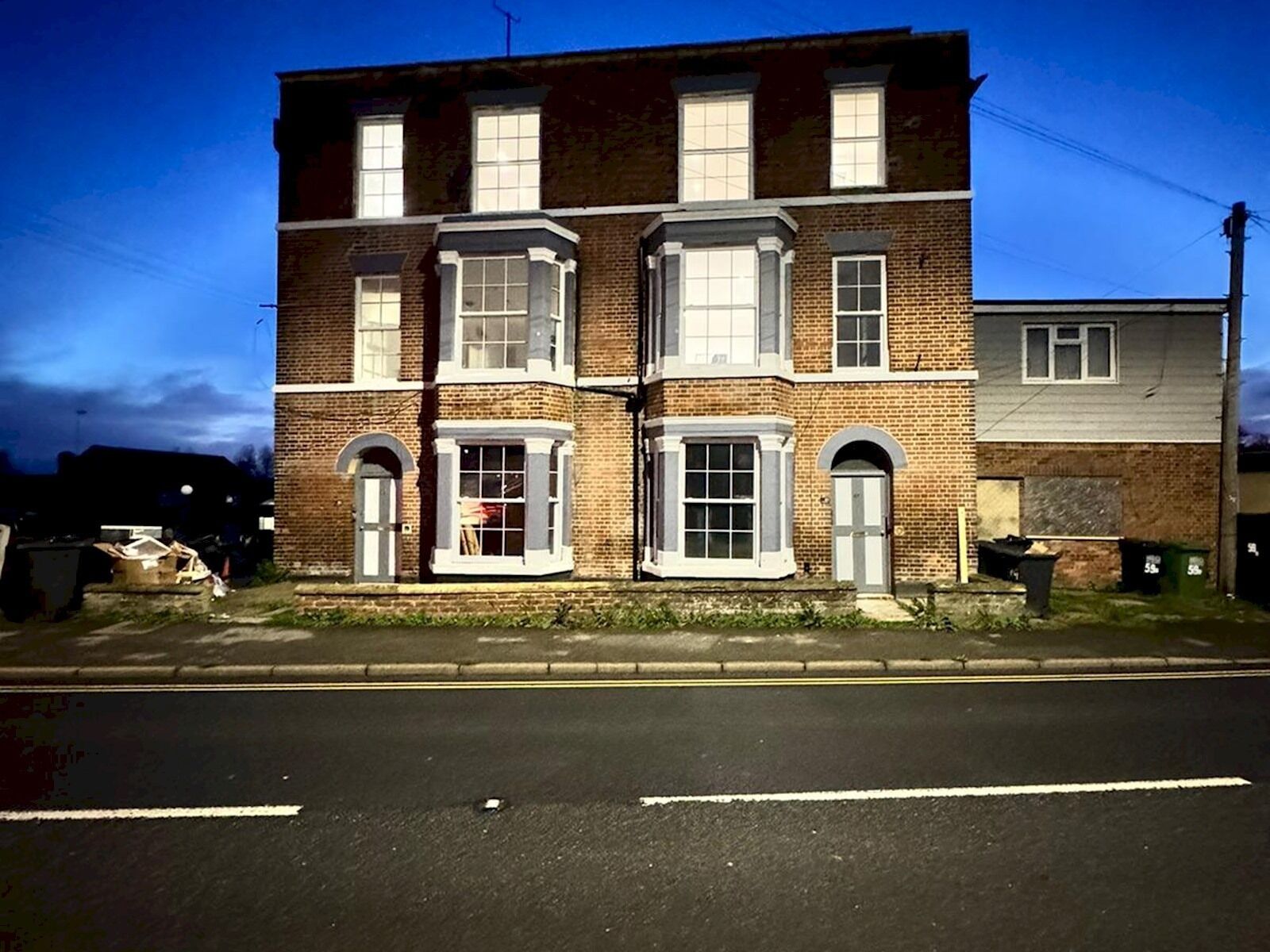 A two-story brick building with bay windows and a flat roof.