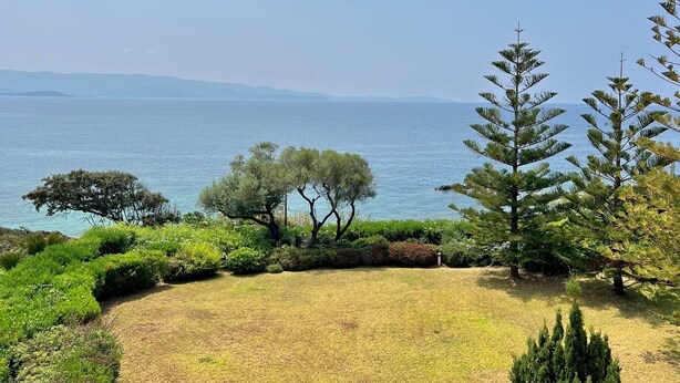 A coastal landscape with a grassy area, trees, and a view of the sea. - Apartment facing the sea (Ajaccio)