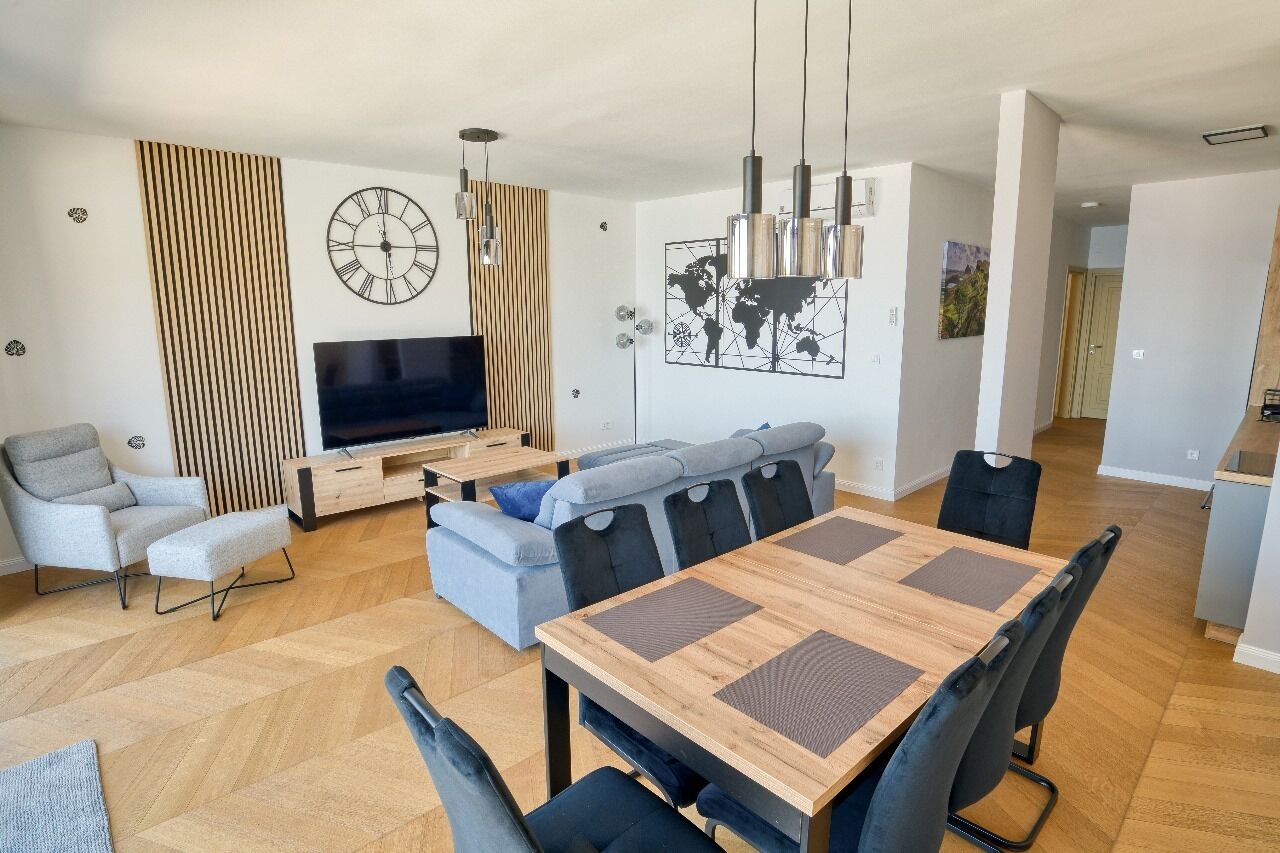 A modern living room with a TV, sofa, and dining table.