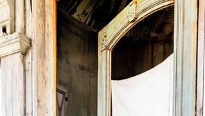 A rustic wooden door with a white cloth hanging on it, leading to a room with a bed and a small table. - 8 Minutes from Round Top!  Your Silo-Bration Destination
StoneHENge Silo #2 (La Grange)