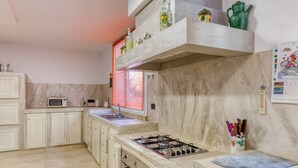 A kitchen with a gas stove, microwave, and cabinets.