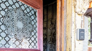 Una puerta de madera con un panel de vidrio decorativo y un picaporte de latón.