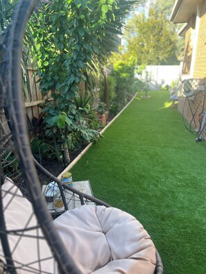 A garden with a green lawn, a wooden fence, and a hammock. - Airport Serenity- Guest Suite with luscious garden- 6 Minutes to Airport (Westmeadows)
