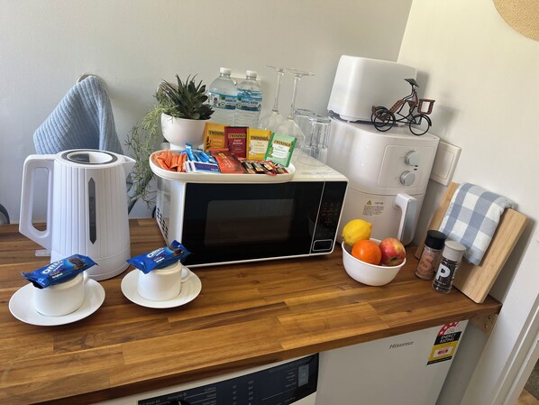 A kitchen counter with a kettle, microwave, and various food items. - Airport Serenity- Guest Suite with luscious garden- 6 Minutes to Airport (Westmeadows)