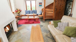 Un accogliente soggiorno con camino, una panca in legno, un divano e una scala.