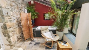 Un patio accogliente con mobili in vimini, un tavolo in legno e piante in vaso.