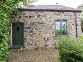 A stone building with a green door and a window.