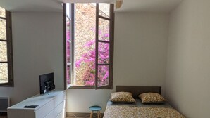 A modern bedroom with a bed, a desk, and a ceiling fan. - Apartment Sète centre-ville (Sète)