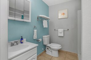 Une salle de bain avec un lavabo blanc, des toilettes et un porte-serviettes.