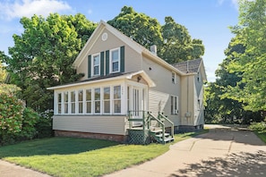 A two-story house with a front porch, a covered entryway, and a visible staircase.