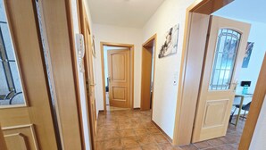 A hallway with wooden doors and tiled flooring.