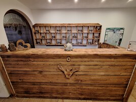Un mostrador de recepción de madera con diseño rústico, una figura de gnomo y un mapa en la pared.