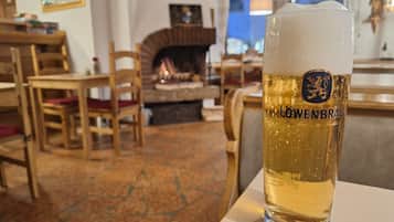 Ein Glas Löwenbräu Bier in stilvoller, rustikaler Umgebung mit Holzmöbeln und Kamin.