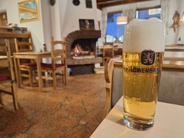 Una cerveza Löwenbräu en un ambiente rústico y acogedor, con muebles de madera y chimenea.