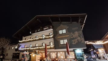 Ein Hotel mit Balkon, Weihnachtsbaum und Sitzgelegenheiten im Freien.
