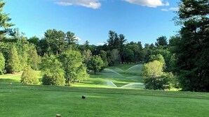 Ein gepflegter Golfplatz unter blauem Himmel mit üppigem Grün.