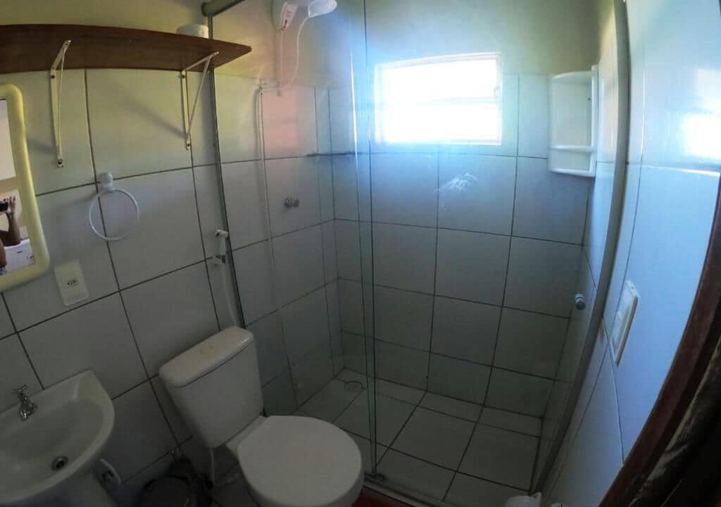Un baño pequeño con inodoro, lavamanos y ducha.