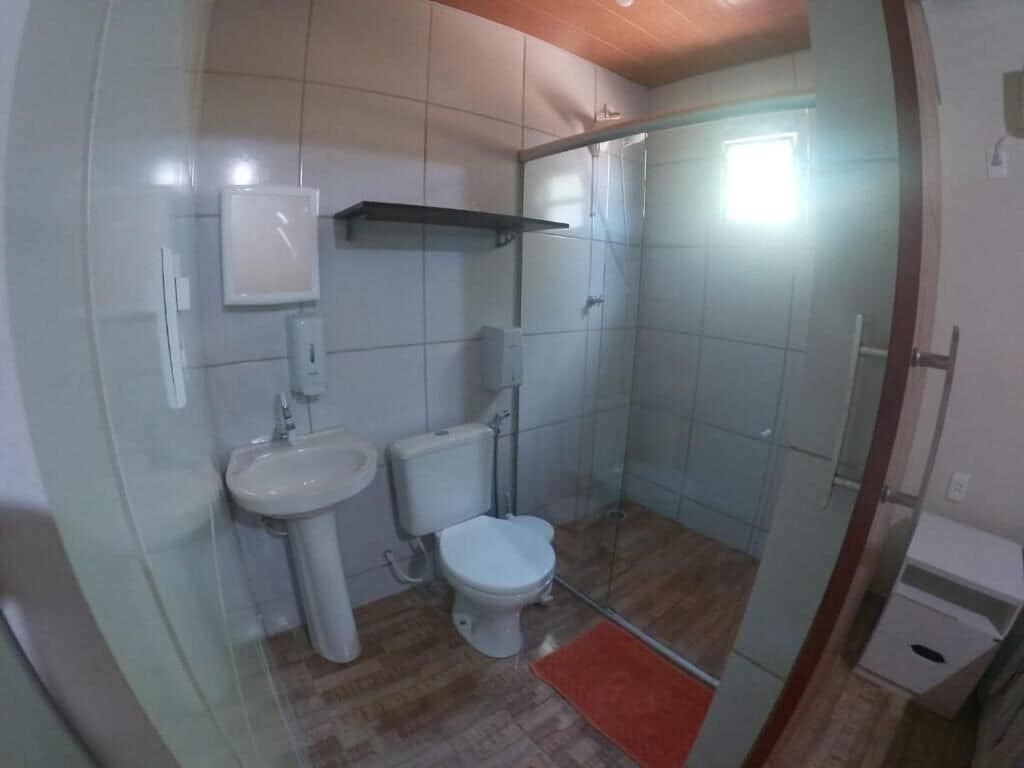 A bathroom with a toilet, sink, and shower area.