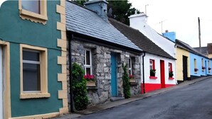A row of colorful houses with stone facades, windows, and doors. - House on the Lane, in the tranquil Village of Cong, Ireland. (MO)