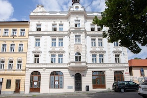 Ein historisches Gebäude mit aufwendigen architektonischen Details, großen Fenstern und einem markanten Eingang.