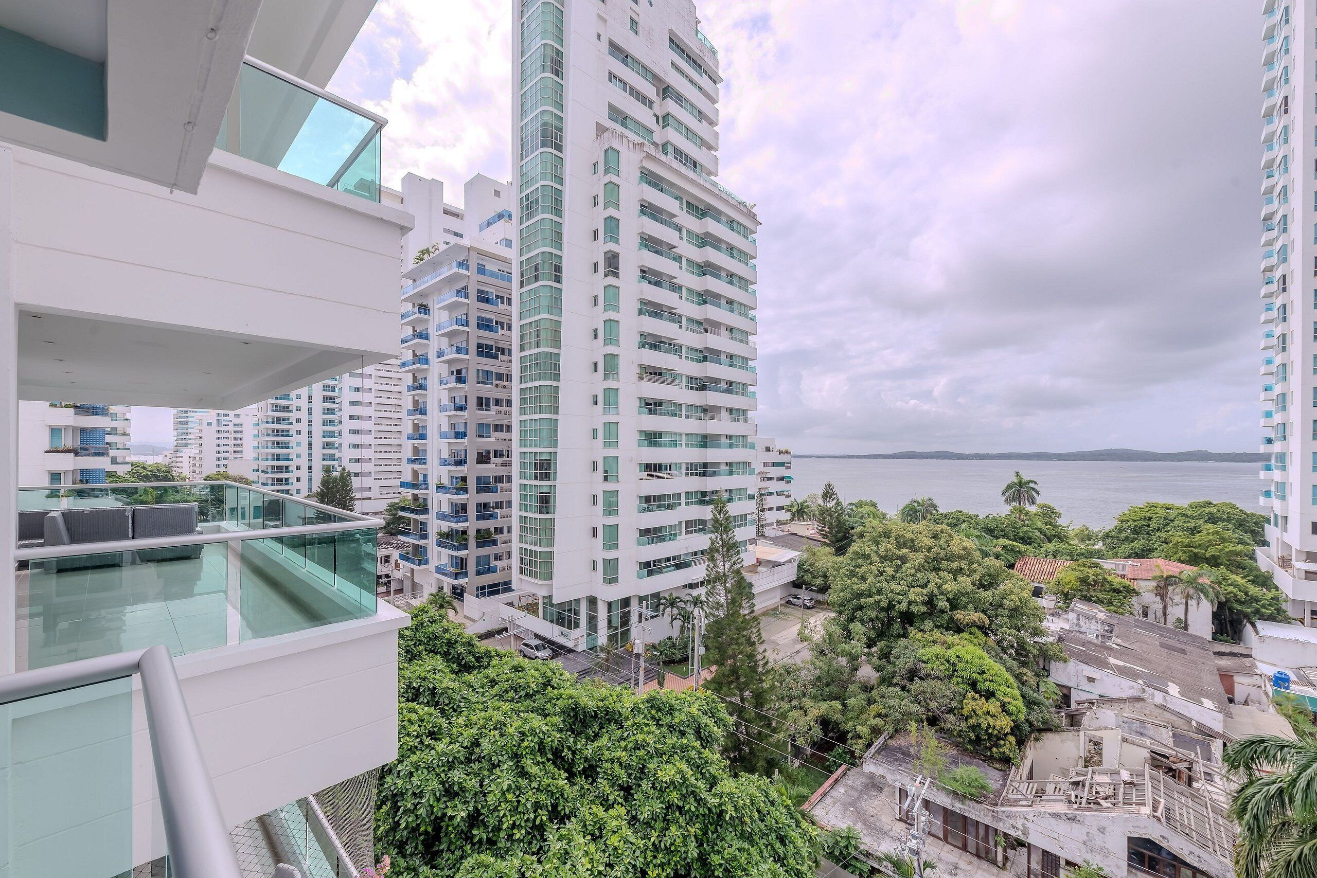 Un immeuble de grande hauteur doté de nombreux balcons, d’une façade en verre et offrant une vue sur la mer.