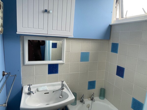 A bathroom with a sink, mirror, and bathtub. There are blue tiles on the walls and a window above the mirror. - 2 Bed Lodge Sleeps 4- Pets, Parking, 2min to Beach (Skegness)